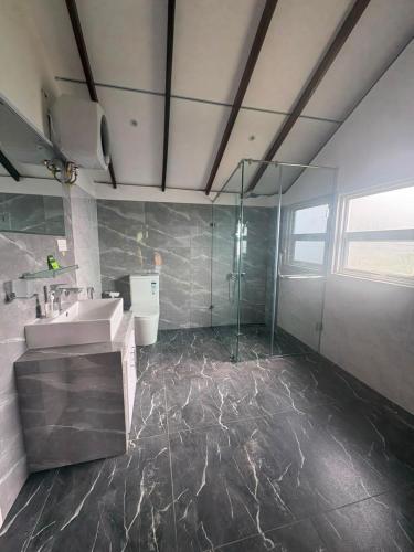 a bathroom with a sink and a glass shower at 7 Crowns Villa Ambewela, Nuwara Eliya in Boragasketiya