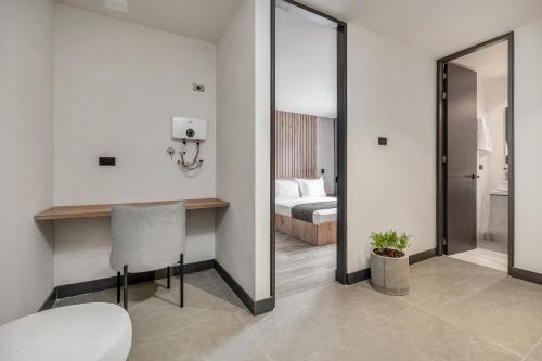 a room with a bed and a table and a mirror at Apartamentos HOUSY Laureles in Medellín