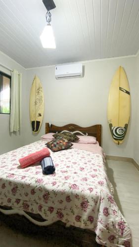 a bedroom with a bed with surfboards on the wall at Pousada Mar Vintage in Laguna