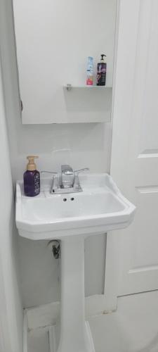 a white sink in a bathroom with a mirror at Hard Rock Area Modern Studio in Miami Gardens