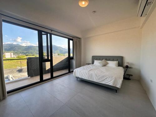 a bedroom with a bed and a large window at wangderfu享富Villa in Dongshan