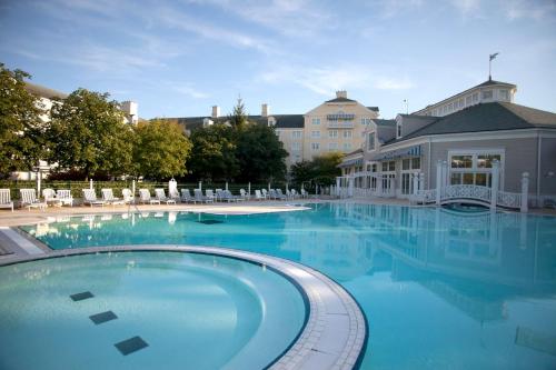 a large swimming pool with chairs and a building at Disney Newport Bay Club in Chessy