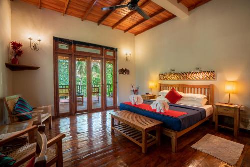 a bedroom with a bed and a table in a room at Jim's Farm Villas in Madawala