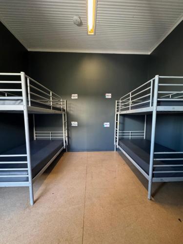 a room with three bunk beds in it at Roebuck Bay Backpackers in Broome