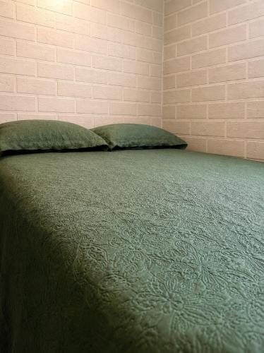 a bed with two pillows on it in a room at Aconchego in Fortaleza