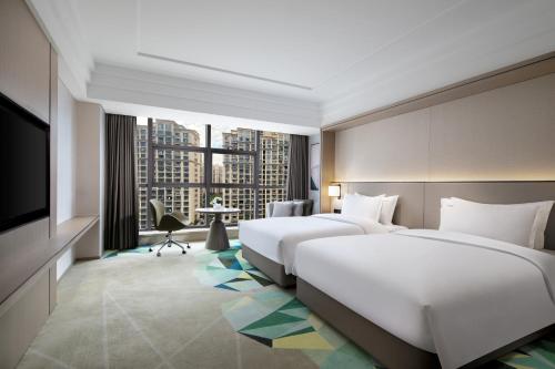 a hotel room with two beds and a television at Holiday Inn Ningde Dijing by IHG in Xiapu