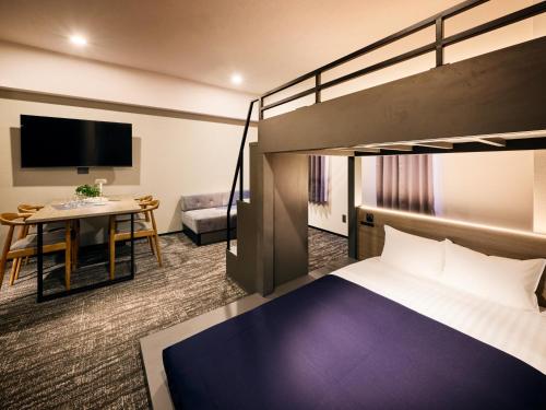 a hotel room with a bunk bed and a table at Minn Hakata Station East in Sumiyoshi