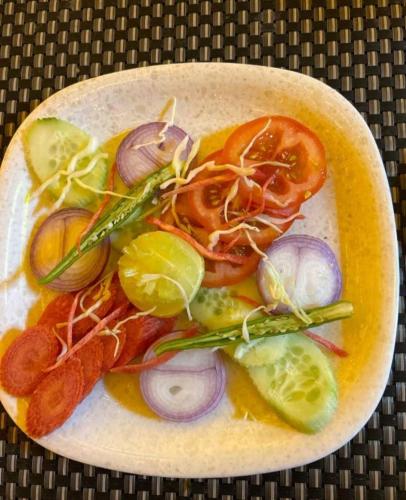 a plate of food with vegetables on a table at Hotel soni plaza in Jhālrapātan