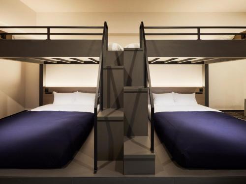 two bunk beds in a room with two beds at Minn Hakata Station East in Sumiyoshi