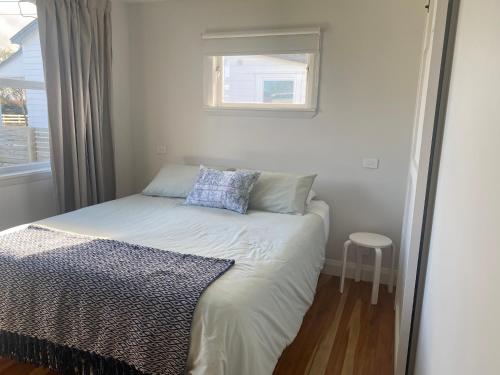 a small bedroom with a bed and a window at Dublin No 5 in Martinborough