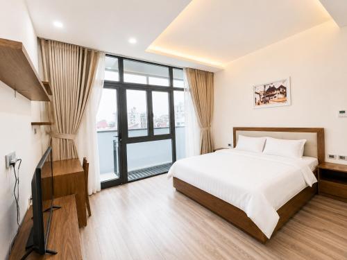 a bedroom with a bed and a large window at Eco Nest Residence in Hanoi