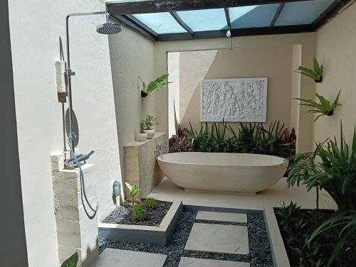 a bathroom with a bath tub in a courtyard at Sri Abi Ratu Villa in Sukawati
