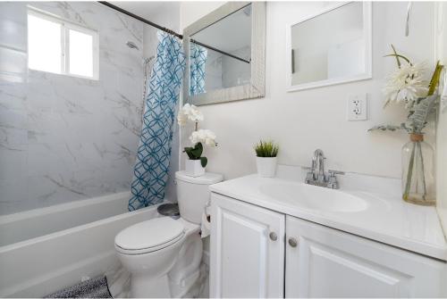 a white bathroom with a toilet and a sink at Comfort and Cozy stay Free parking on site in Oakland