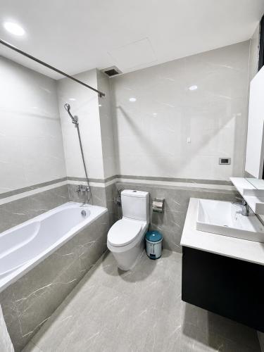 a bathroom with a tub and a toilet and a sink at Eco Nest Residence in Hanoi