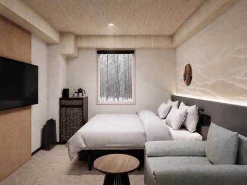 a bedroom with a bed and a couch and a window at Mercure Niseko Resort Formerly known as Midtown Niseko in Kutchan