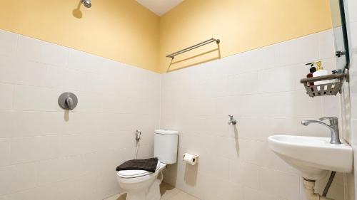 a bathroom with a toilet and a sink at Ventions Sharia Hotel in Jomblang