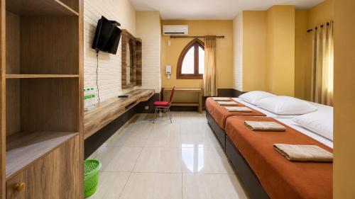 a hospital room with two beds and a tv at Ventions Sharia Hotel in Jomblang