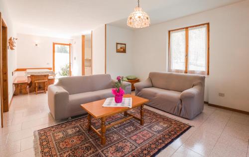 Sala de estar con 2 sofás y mesa en Casa Oasi, en Ledro