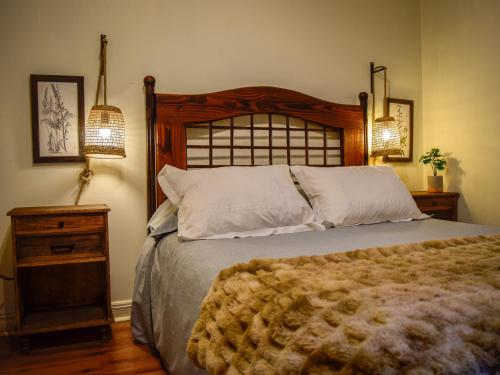 a bedroom with a large bed with a wooden headboard at Refugio en Camino a Farellones in Lo Barnechea