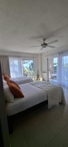 a bedroom with a large bed with a ceiling fan at Hotel Majo Sayulita in Sayulita