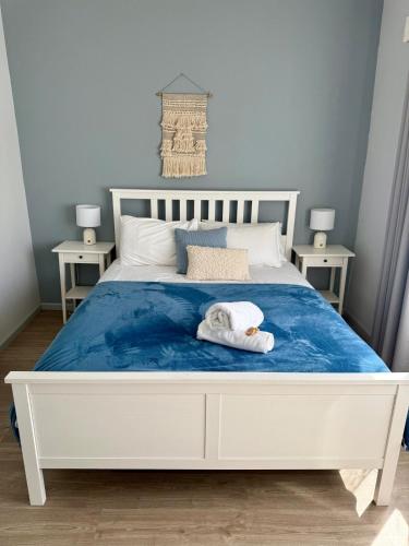 a bedroom with a white bed with a towel on it at Gate Access to the Beach in Edithvale