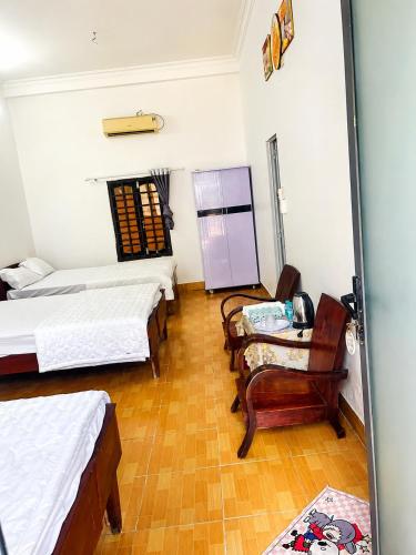 a room with three beds and a table and chairs at Khách sạn Thu Hòn Rơm Phan Thiết in Phan Thiet