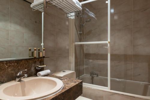 y baño con lavabo y ducha. en Neuilly Park Hotel, en Neuilly-sur-Seine