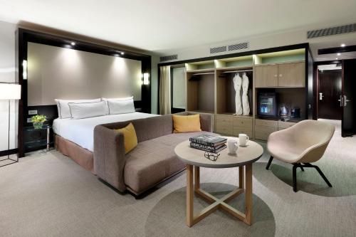 a hotel room with a bed and a couch and a table at Meliá Barcelona Sarrià in Barcelona