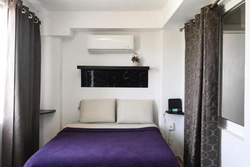 a small bedroom with a purple bed in a room at Estudio compacto en Riviera Diamante con alberca in Acapulco