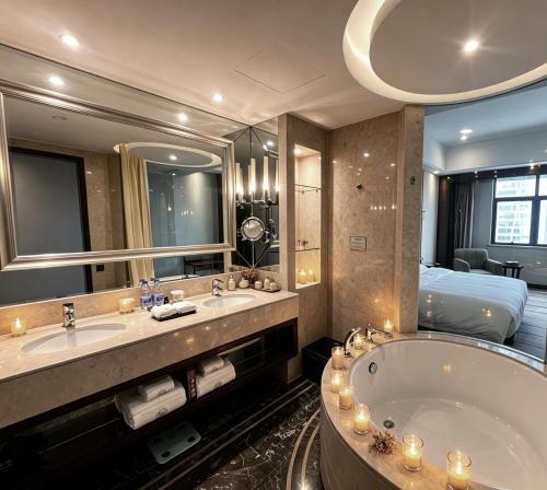 a bathroom with two sinks and a tub and a bed at Lv Shou Hotel in Shanghai