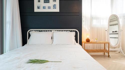 a bedroom with a white bed with a blue wall at Taean anmyeondo hwangdo ilmare Pension in Taean