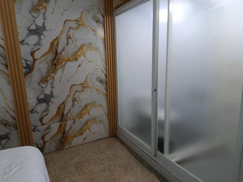 a bedroom with a sliding glass door next to a wall at River cliff guest house in Gunungsriti