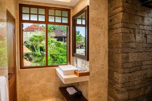 a bathroom with a sink and a window at Mumbul Ubud in Ubud