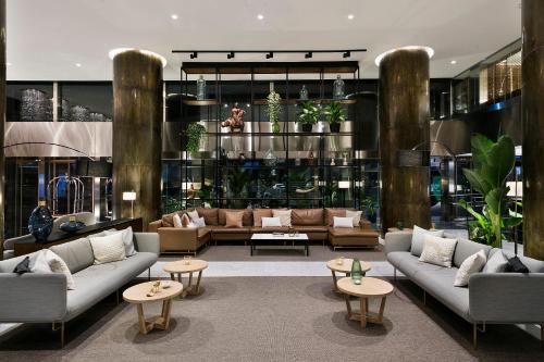 a living room with couches and tables and plants at Meliá Madrid Princesa in Madrid