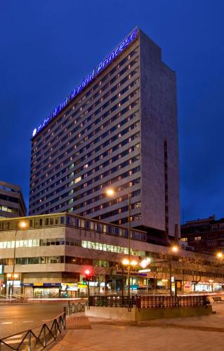 a tall building with a lit up sign on it at Meliá Madrid Princesa in Madrid
