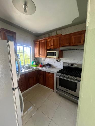 a kitchen with wooden cabinets and a stove top oven at Serenity Escape in Runaway Bay