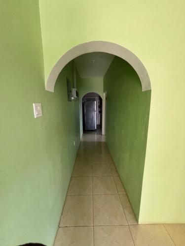 an empty hallway with green walls and a tile floor at Serenity Escape in Runaway Bay