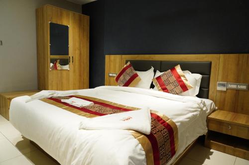 a bedroom with a large bed with white sheets and red pillows at MRM Grand Park in Pudukkottai
