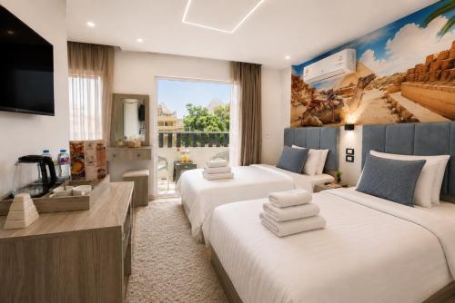 a hotel room with two beds and a flat screen tv at Golden RZ pyramids view in Cairo