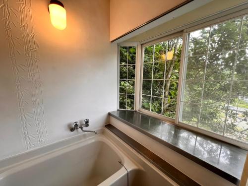 a bath tub in a bathroom with a window at 伊豆ビーチクラブ in Shimoda