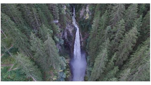 an aerial view of a waterfall in a forest at Gasthof Schütthof in Neukirchen am Großvenediger