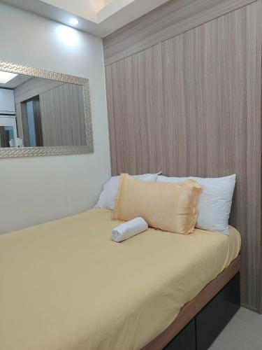 a bedroom with a bed with a mirror and pillows at VP luxury moa staycation in Manila