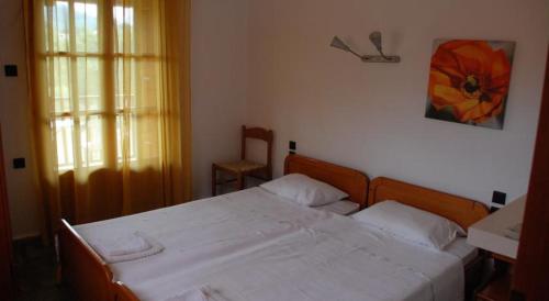a bedroom with a large white bed and a window at Panormos Palace in Panormos Skopelos