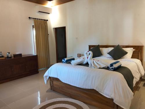 a bedroom with a large bed with stuffed animals on it at Japa Amerta Villa in Amed