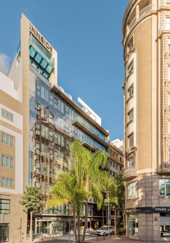 a tall building with a palm tree in front of it at INNSiDE by Meliá Tenerife Santa Cruz in Santa Cruz de Tenerife