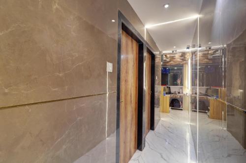 a hallway with a glass door and a bathroom at Hotel Omega in Mumbai