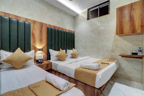 a hotel room with two beds and azeb sidx sidx sidx at Hotel Omega in Mumbai