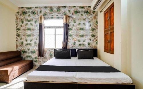 a bedroom with a bed in a room with a window at Hotel soni plaza in Jhālrapātan