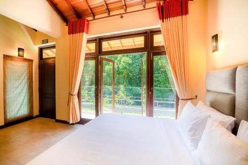 a bedroom with a bed and a large window at Riverdale lagoon villas in Aluthgama