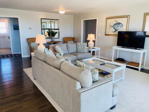 a living room with a couch and a tv at Dune Deck North - Duplex in Holden Beach